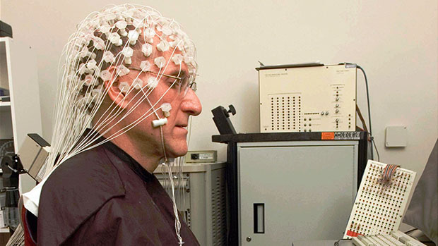 Picture of a person wearing a research EEG headset with many electrodes