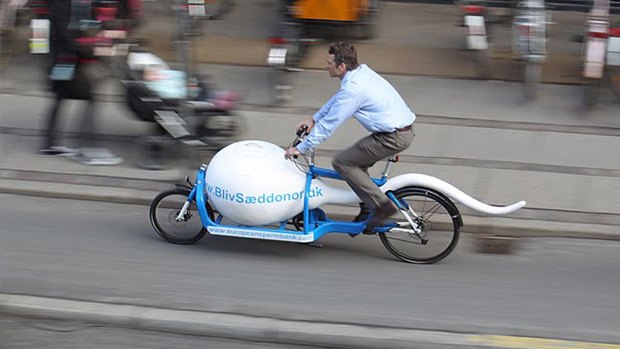 A man riding a sperm-shaped bike