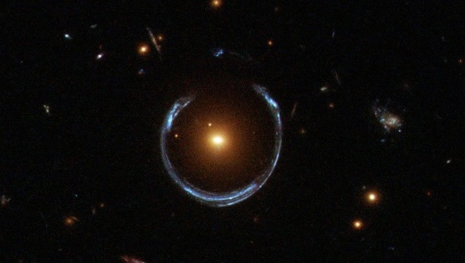 Light from one faraway galaxy is distorted into a ring around a closer galaxy.