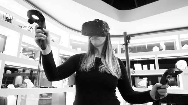 Woman wearing VR headset and holding controllers.