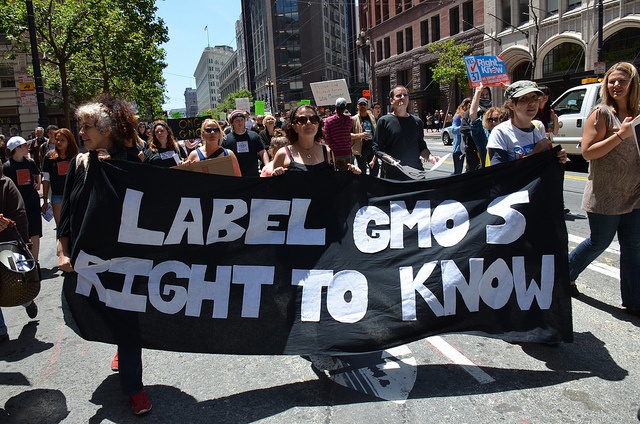 Protesters hold signs to support the labelling of genetically modified foods.