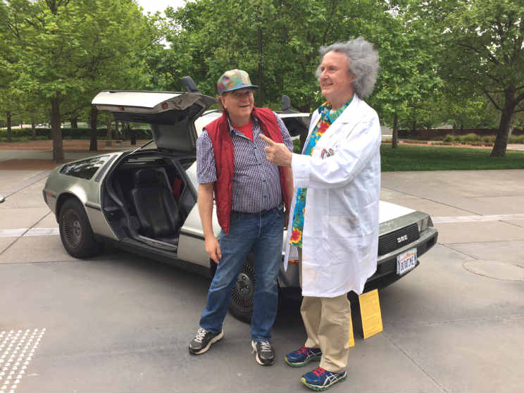 Brian Schmidt and Les Field dressed as Marty and Doc standing in front of a DeLorean