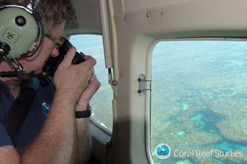 Professor Terry Hughes taking photos of a reef from a plane