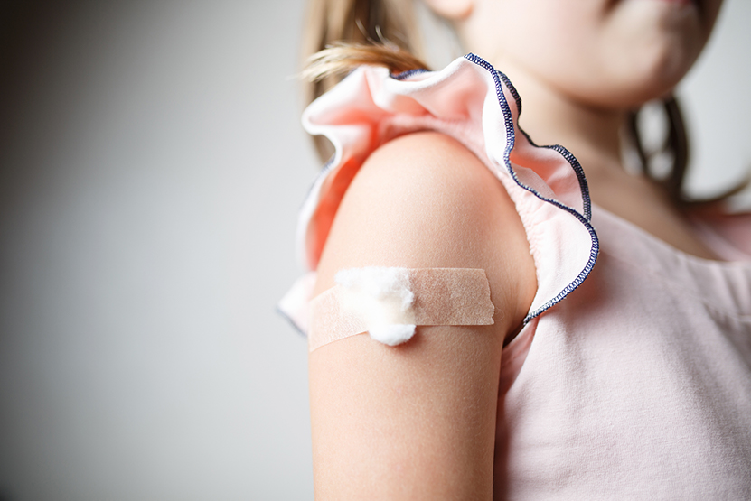Upper arm of young girl with bandaid on it