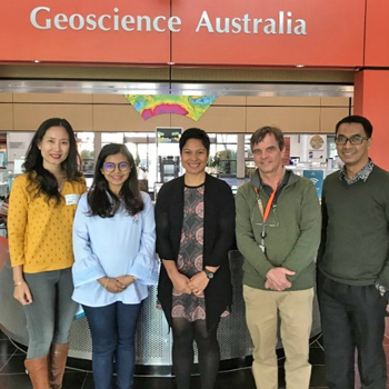 People standing in front of a Geoscience Australia sign