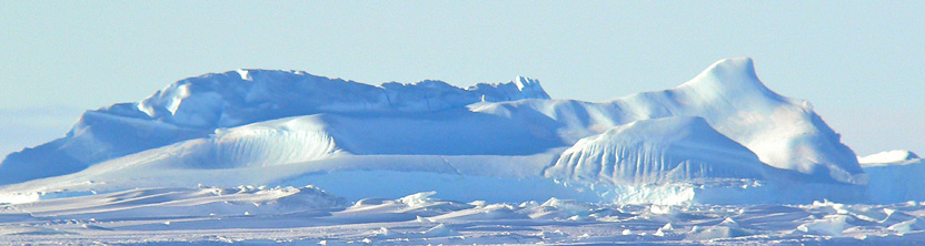 Pale blue ice- and snow-covered mountains under a blue sky
