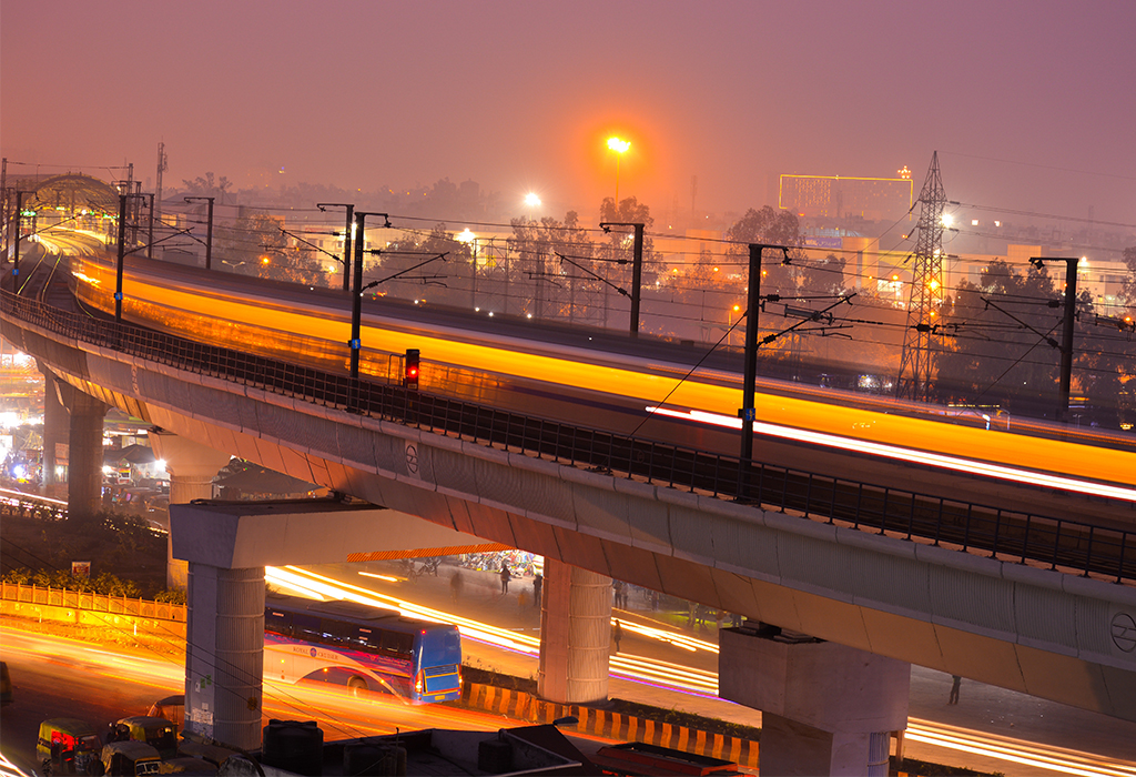 A bridge and traffic at night in a smog-filled urban landscape