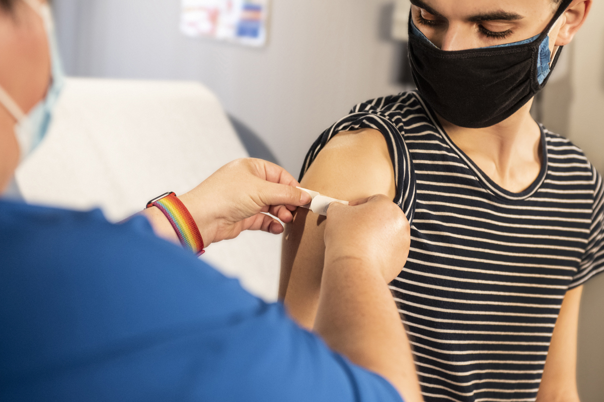 A person getting a bandaid applied after vaccination