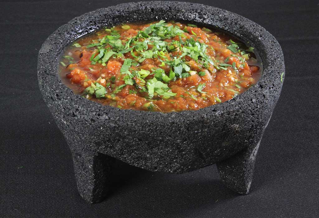 A bowl of salsa with coriander sprinkled on top
