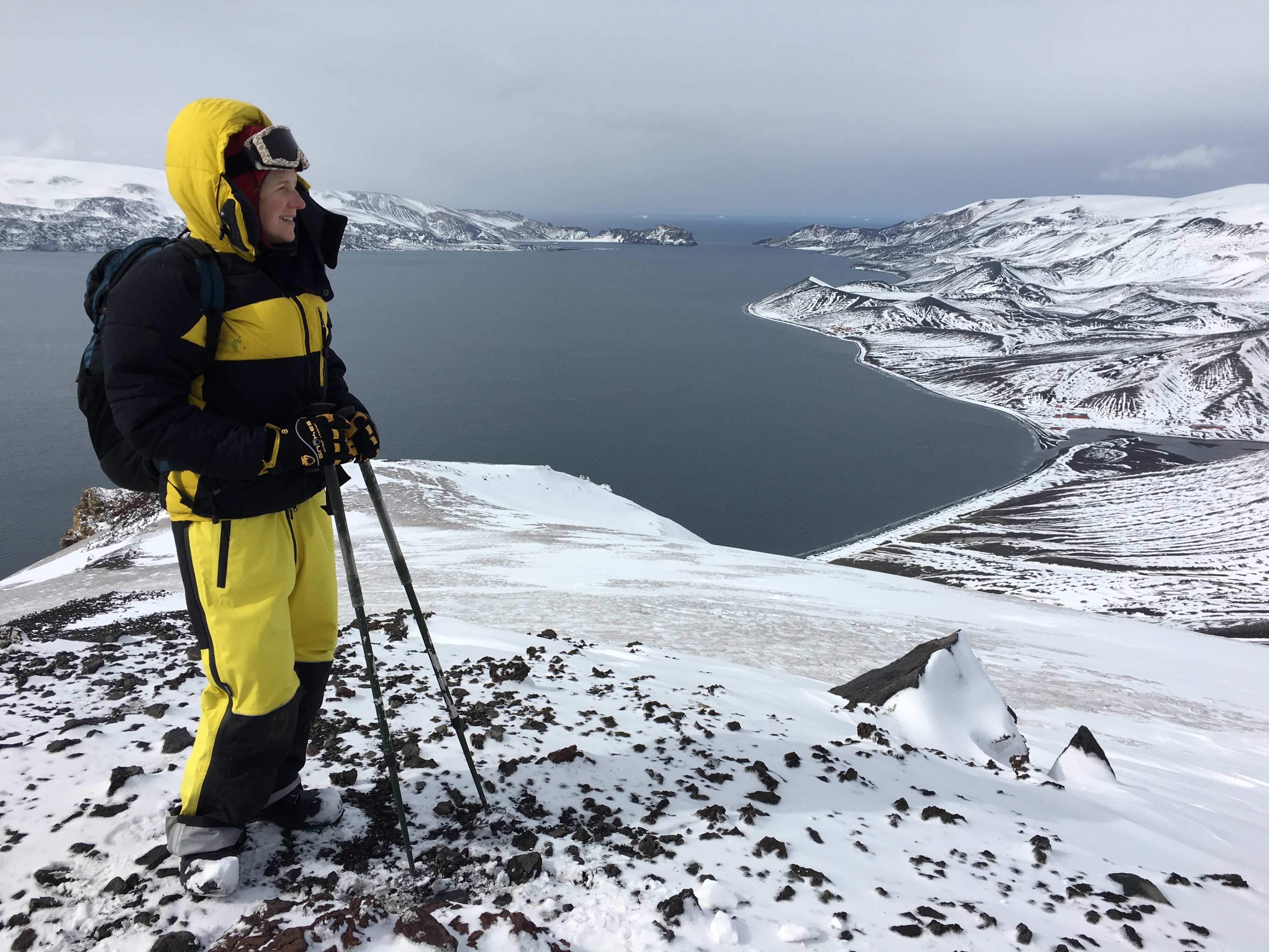 A woman standing on top of a mountain in Antarctica