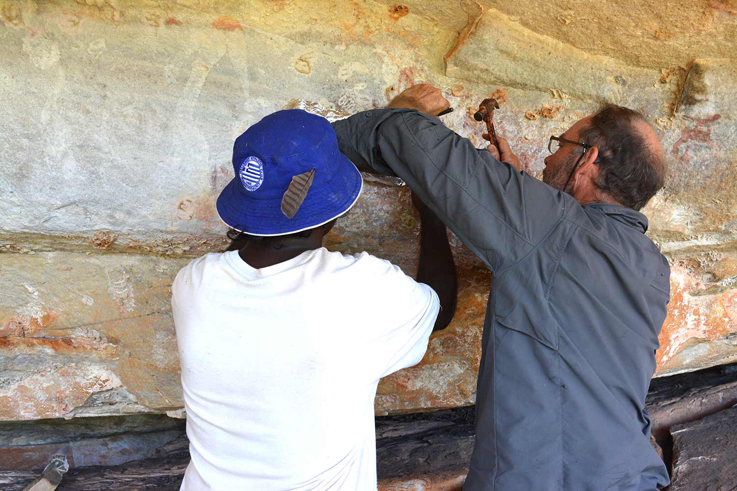 People collecting samples from rock art location