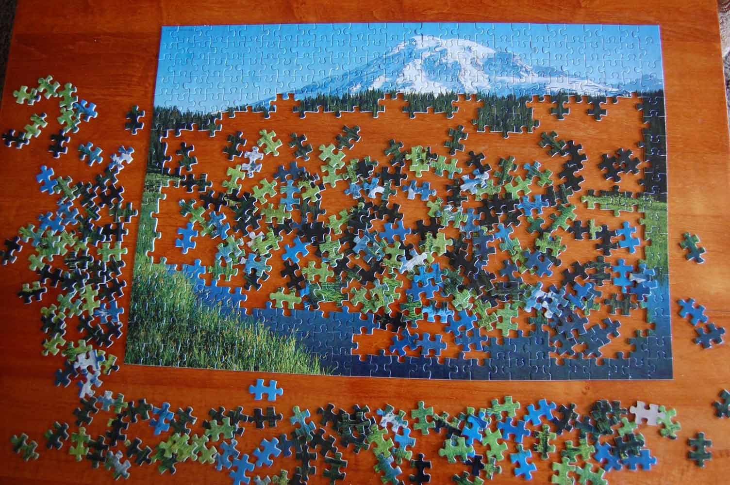 Photo of a half-finished jigsaw puzzle depicting a mountain