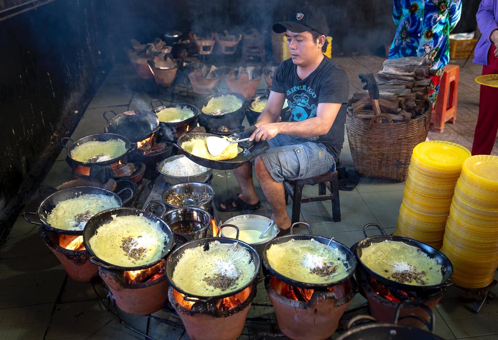 A person cooks using open fires.