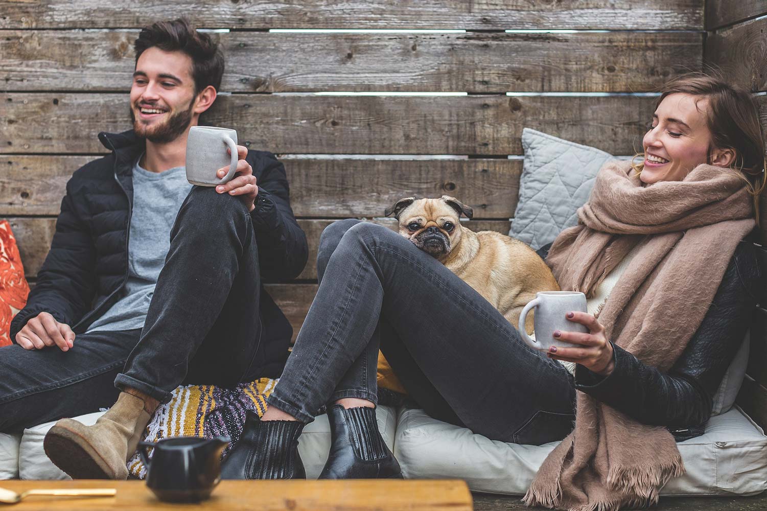 Young man and woman drinking tea with a dog