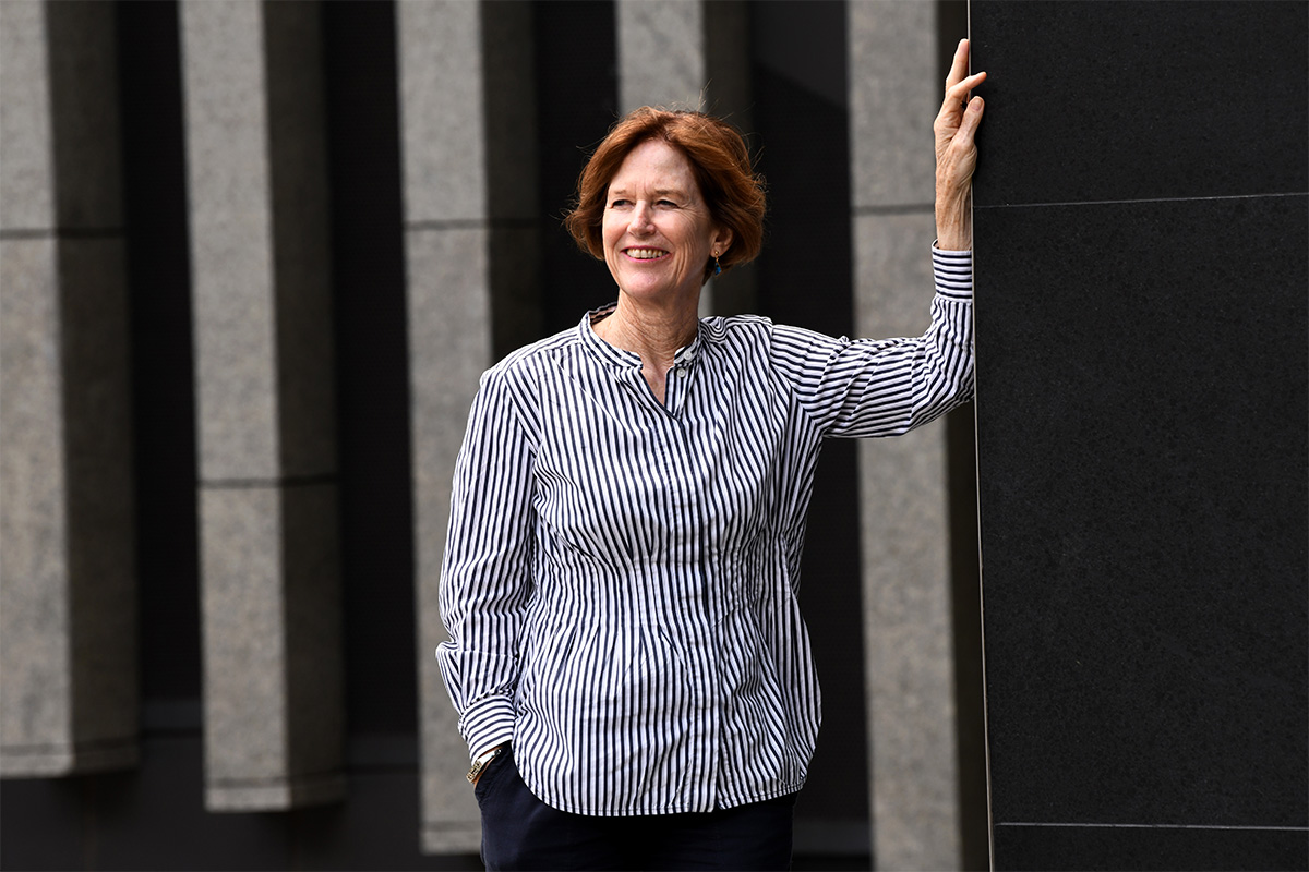 Professor Robyn Owens stands near a large grey building.