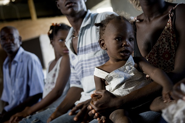 A child waits with her mother for medical treatment and re-hydration kits in Haiti during a cholera outbreak.