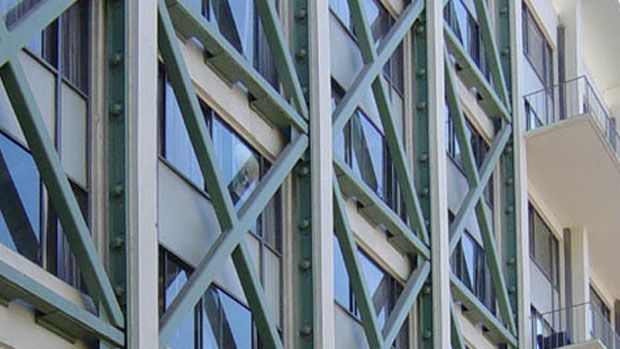 Outside of a building showing steel trusses in criss-cross pattern.