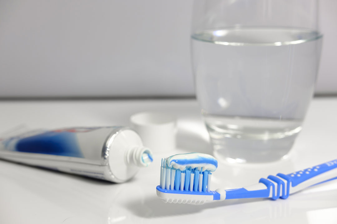 Toothbrush with toothpaste and a glass of water