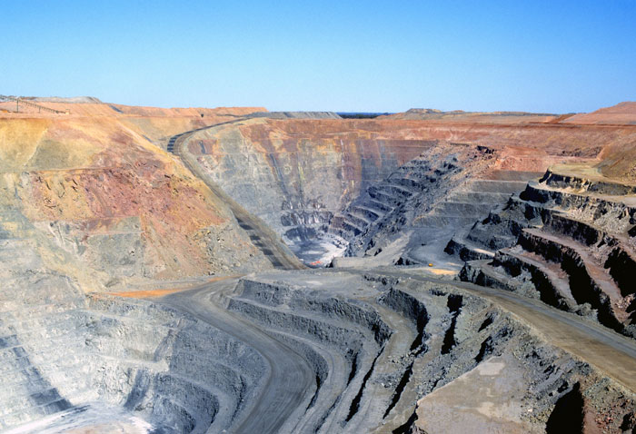 Rock steps cut into the red earth in a large open cut mine.