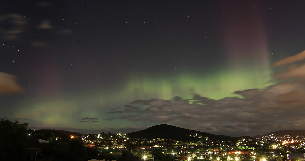 Auroras seen over a city skyline at night
