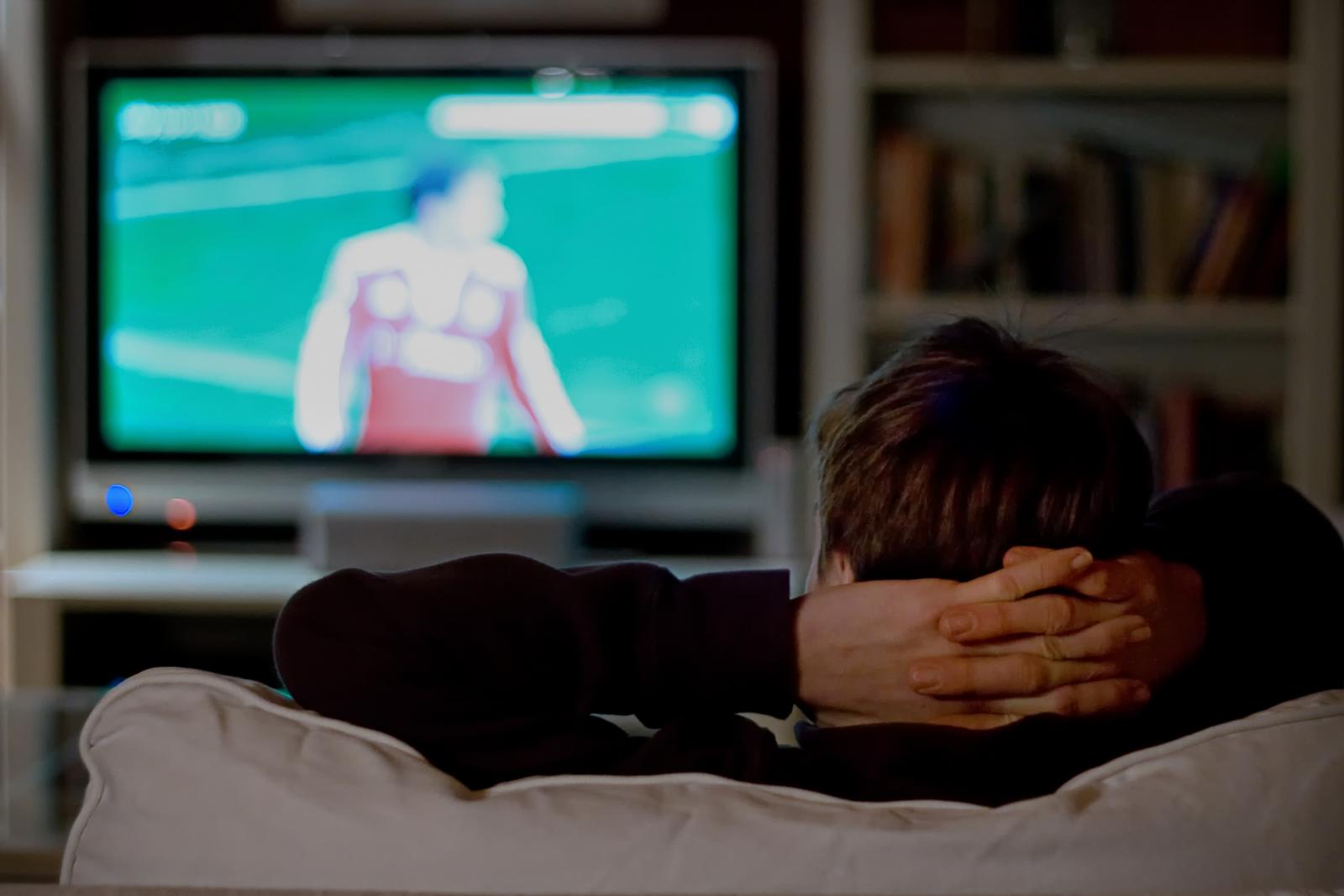 A person watching sport on their TV