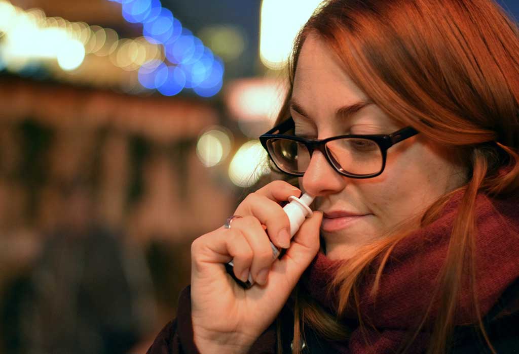 Someone using a nasal spray