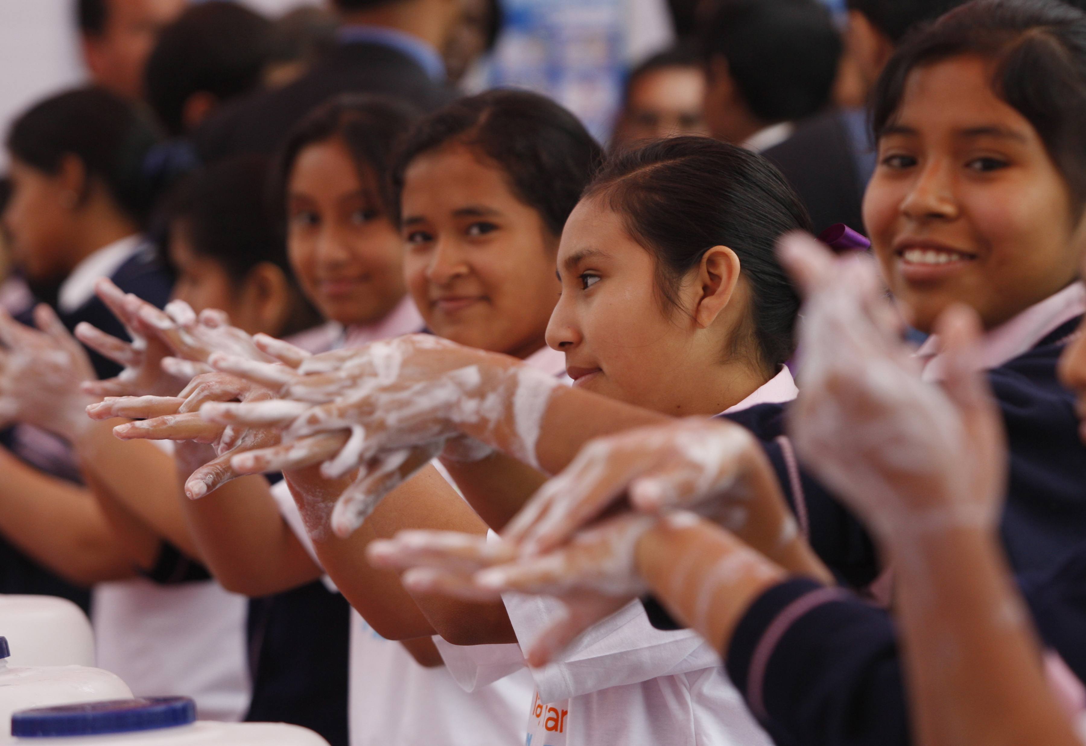 Picture of schoolgirls washing hands with soapy water.