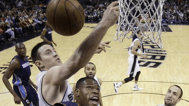 A basketball player taking a shot at the hoop.