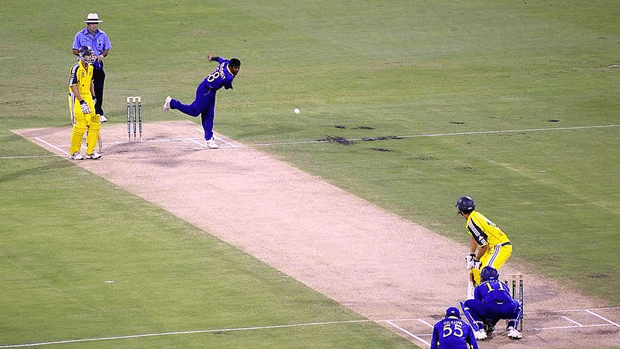 A cricket match, showing the bowler bowling the ball to the batsman.