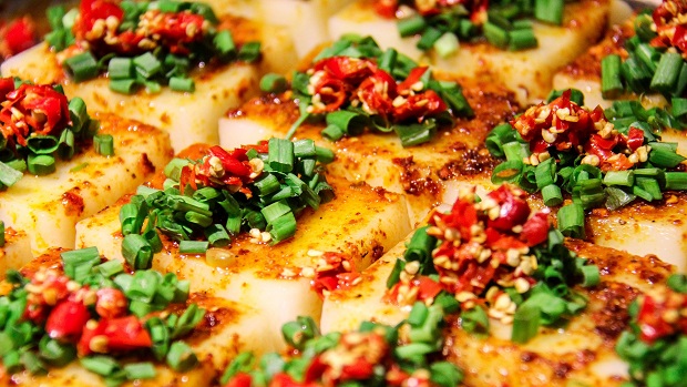 Light brown slices of tofu topped with chilli and spring onion