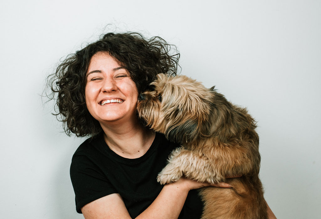 Dog nosing the face of a grinning person.