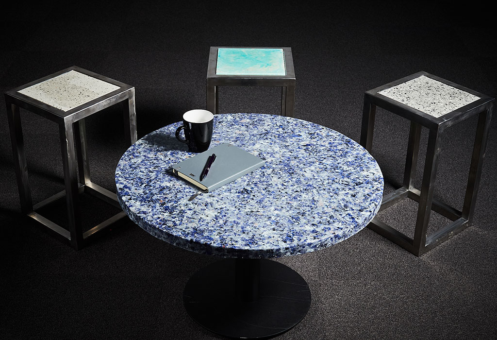 A round coffee table and three stools with textured appearance