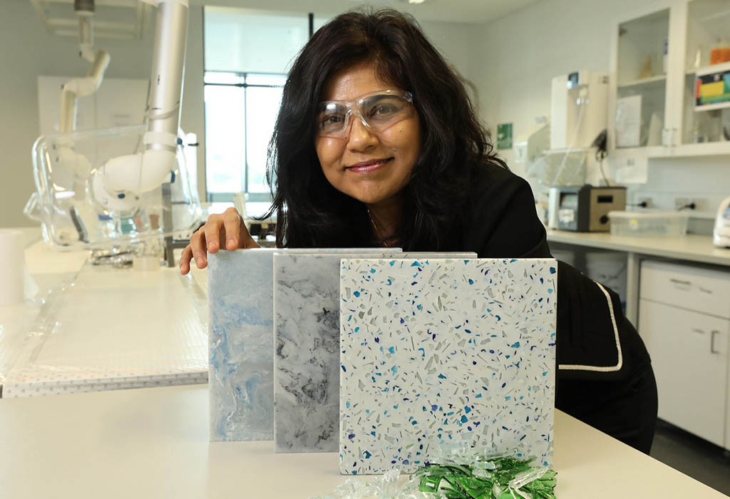 Prof Veena Sahajwalla holding some ceramic tiles with textured appearance