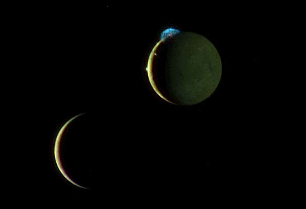 Io (top right) erupting with three volcanic plumes and Europa (bottom left) as they move past each other