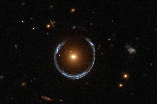 The light from distant galaxies is distorted into a ring as it passes by the gravity of closer objects.