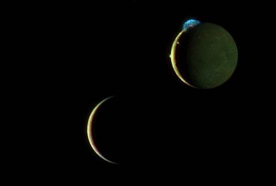 Io (top right) erupting with three volcanic plumes, and Europa (bottom left) as they move past each other.