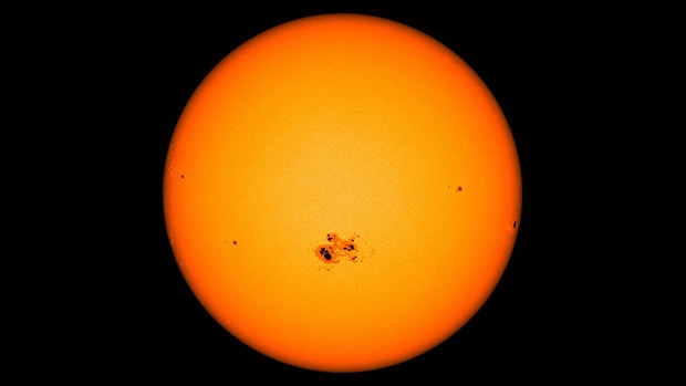 A cluster of dark spots (sunspots) on the surface of the sun.