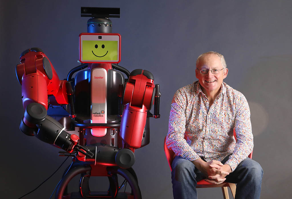 A robot standing next to Prof Toby Walsh