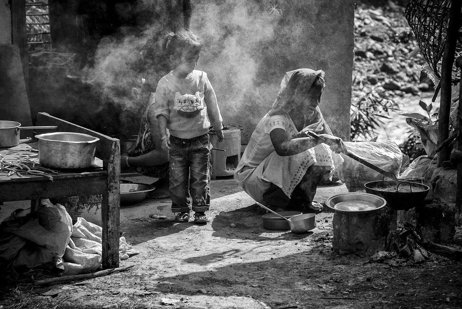 A woman and child cooking in the street, Nepal