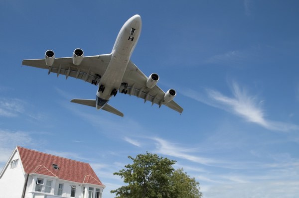 Jet aircraft landing approach over suburban housing