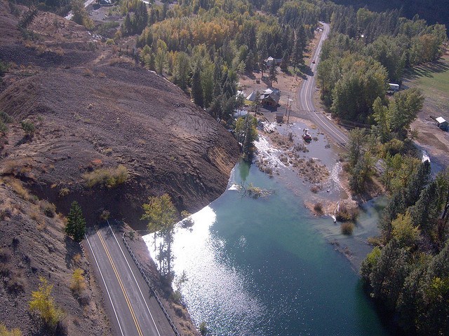 Aerial view of landslide burying a road and a damming a river