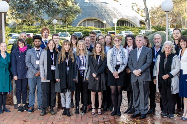 Group of  young people with astronaut Andy Thomas and other older people outside the Shine Dome