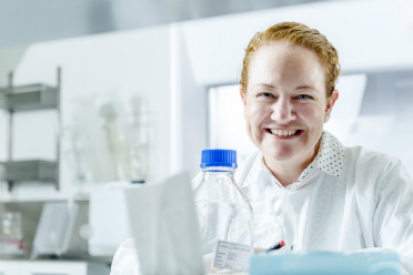 Dr Nikola Bowden in a laboratory, wearing a white lab coat