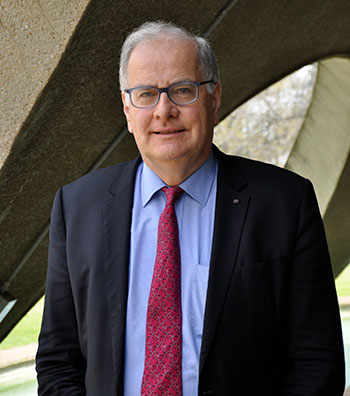 Professor Sam Berkovic standing under the arches of the Shine Dome