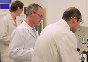 Man in laboratory with other scientists