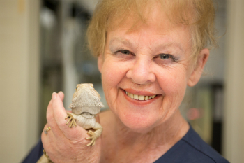 Jenny Graves smiling and holding a lizard