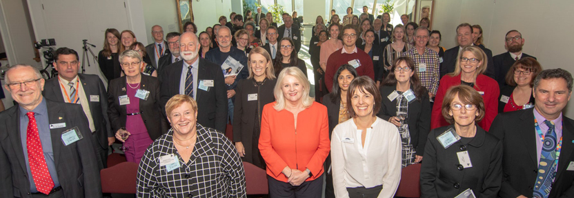 Large group of people smiling at camera, with Karen Andrews and Anna-Maria Arabia in centre front