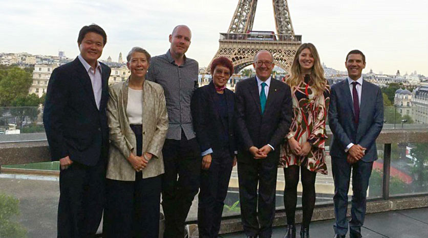 Smiling group stands in front of the Eiffel Tower