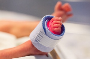Tiny foot of a premature baby, wrapped in a bandage