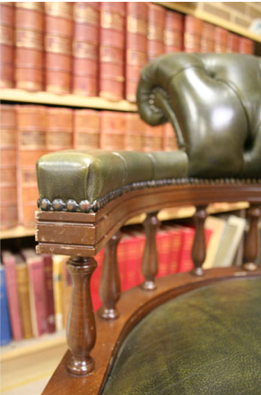 Green leather chair with bookshelves in background